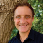Headshot of John Gamber in front of a tree